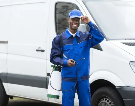 Smiling Pest Control worker in a blue uniform