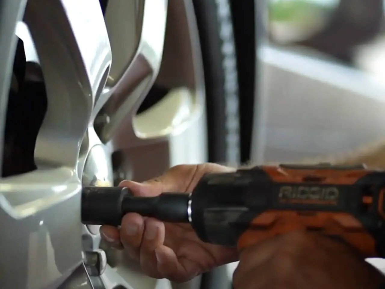 Grease Pro technician shown using impact wrench on wheel lug nuts