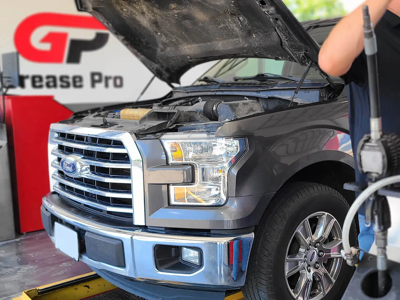 Grease Pro Auto Repair Services - Truck shown parked over service pit with hood open for service