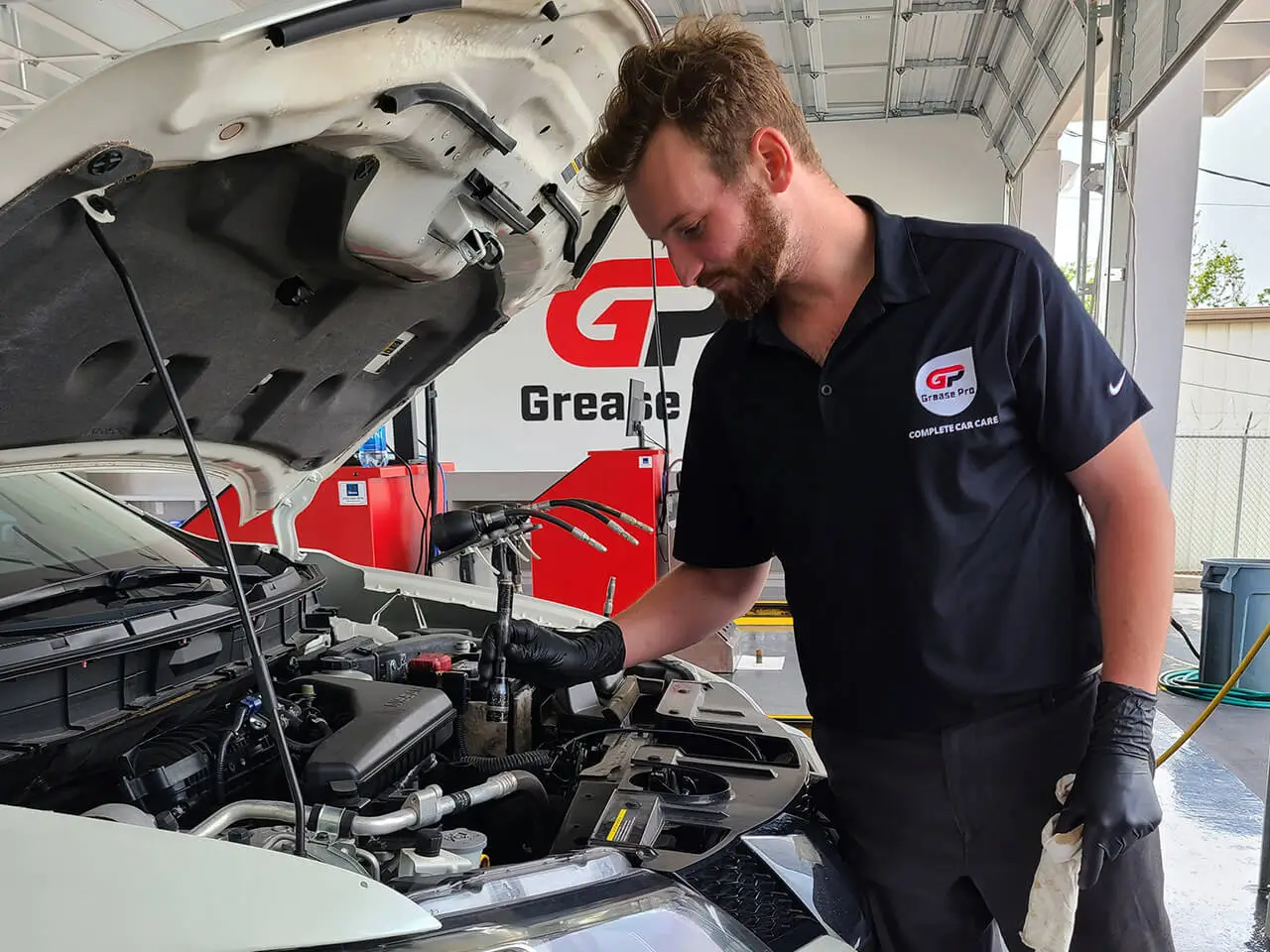 Grease Pro Auto Repair Services Technician Performing Vehicle Engine Bay Inspection