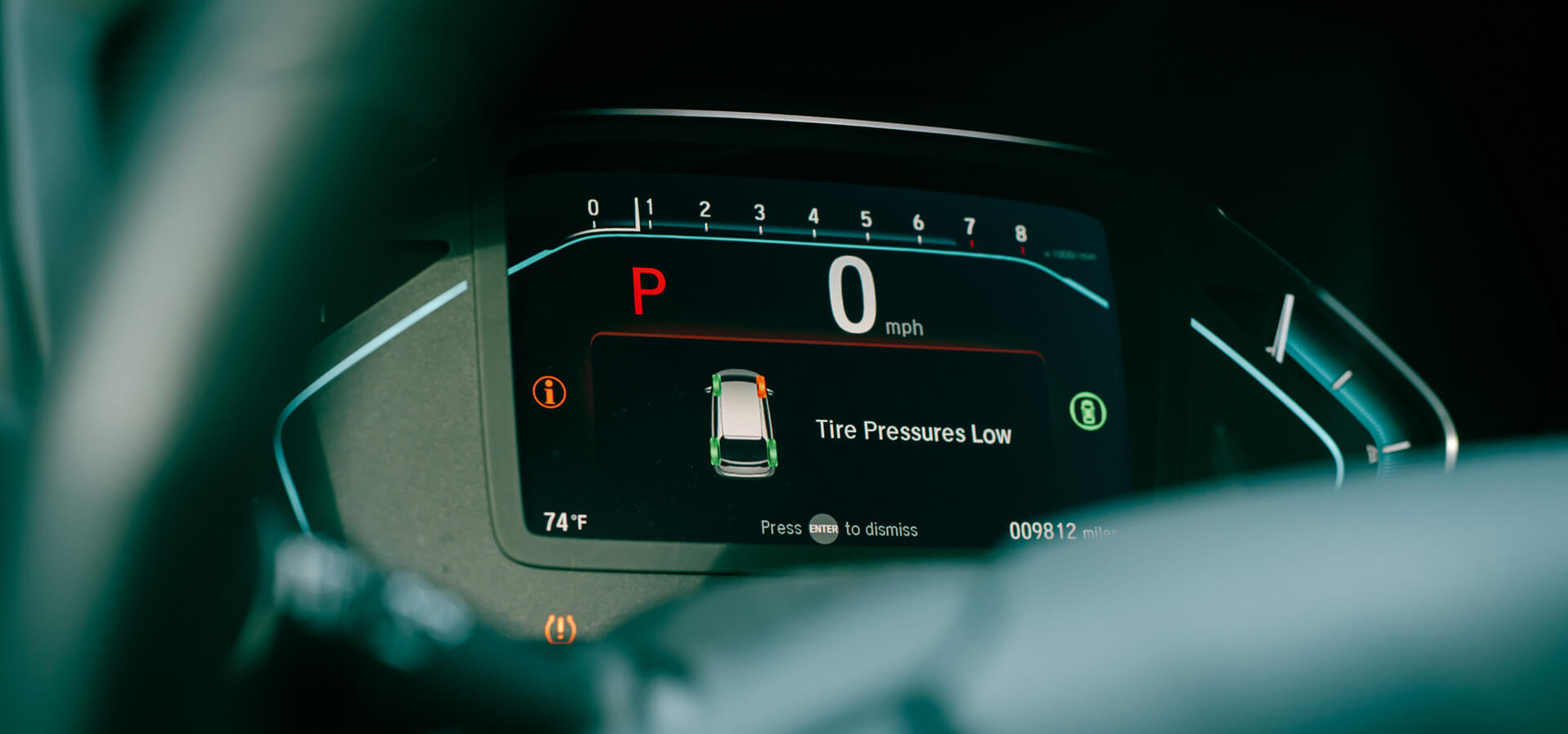 Dashboard warning showing low tire pressure alert on TPMS system